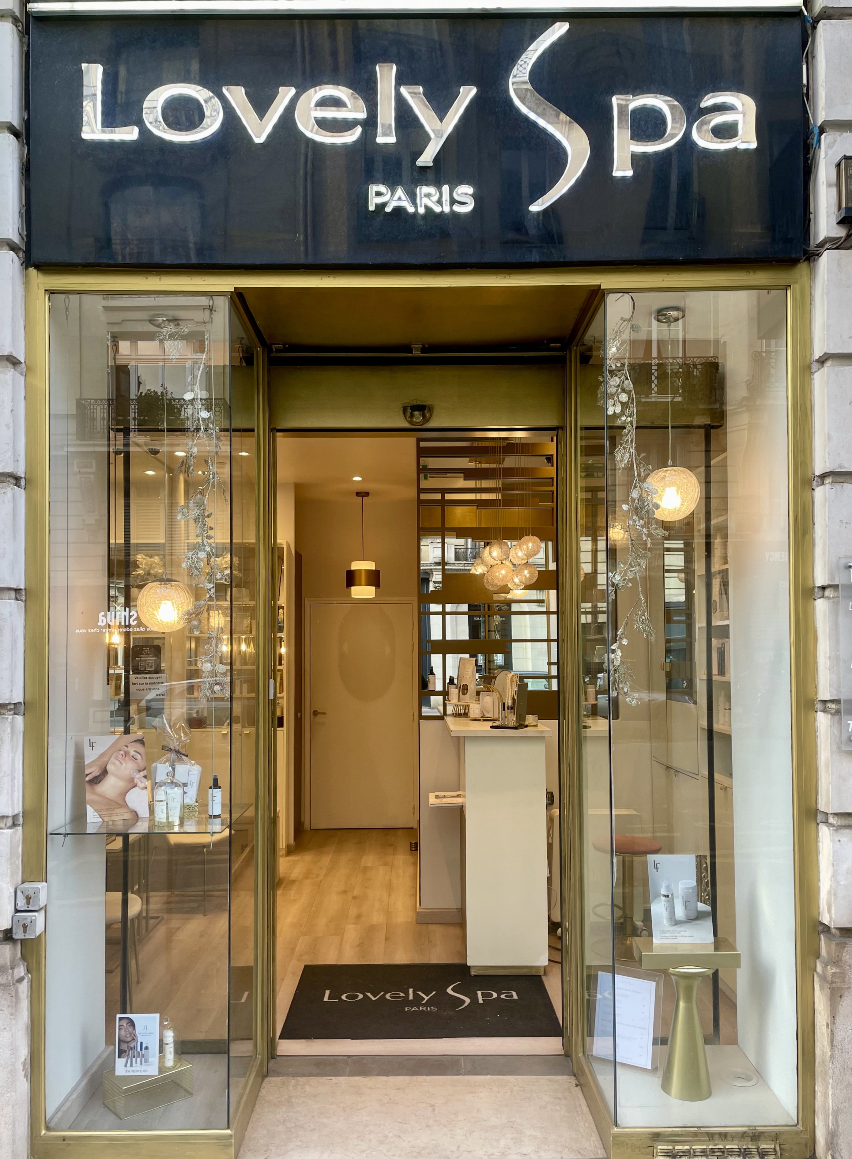 Entrée du Lovely Spa à Paris avec des vitrines et une décoration moderne.